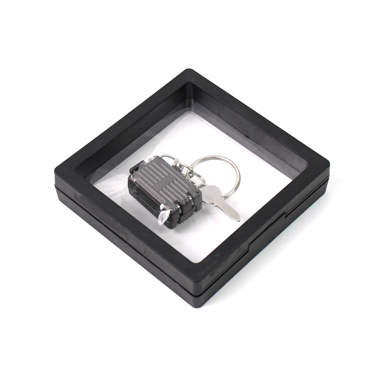 Wukusy suitcase-shaped nail clipper keychain with key, displayed in a 3D floating frame display case, for health care and grooming.