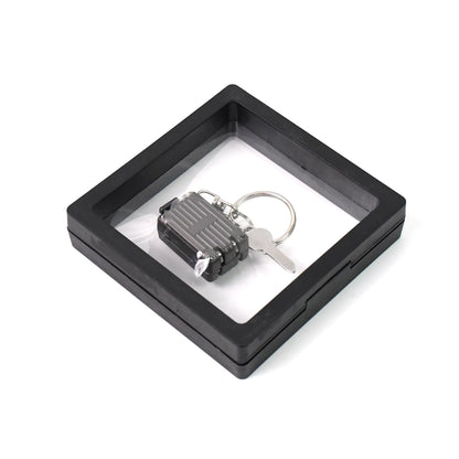 Wukusy suitcase-shaped nail clipper keychain with key, displayed in a 3D floating frame display case, for health care and grooming.