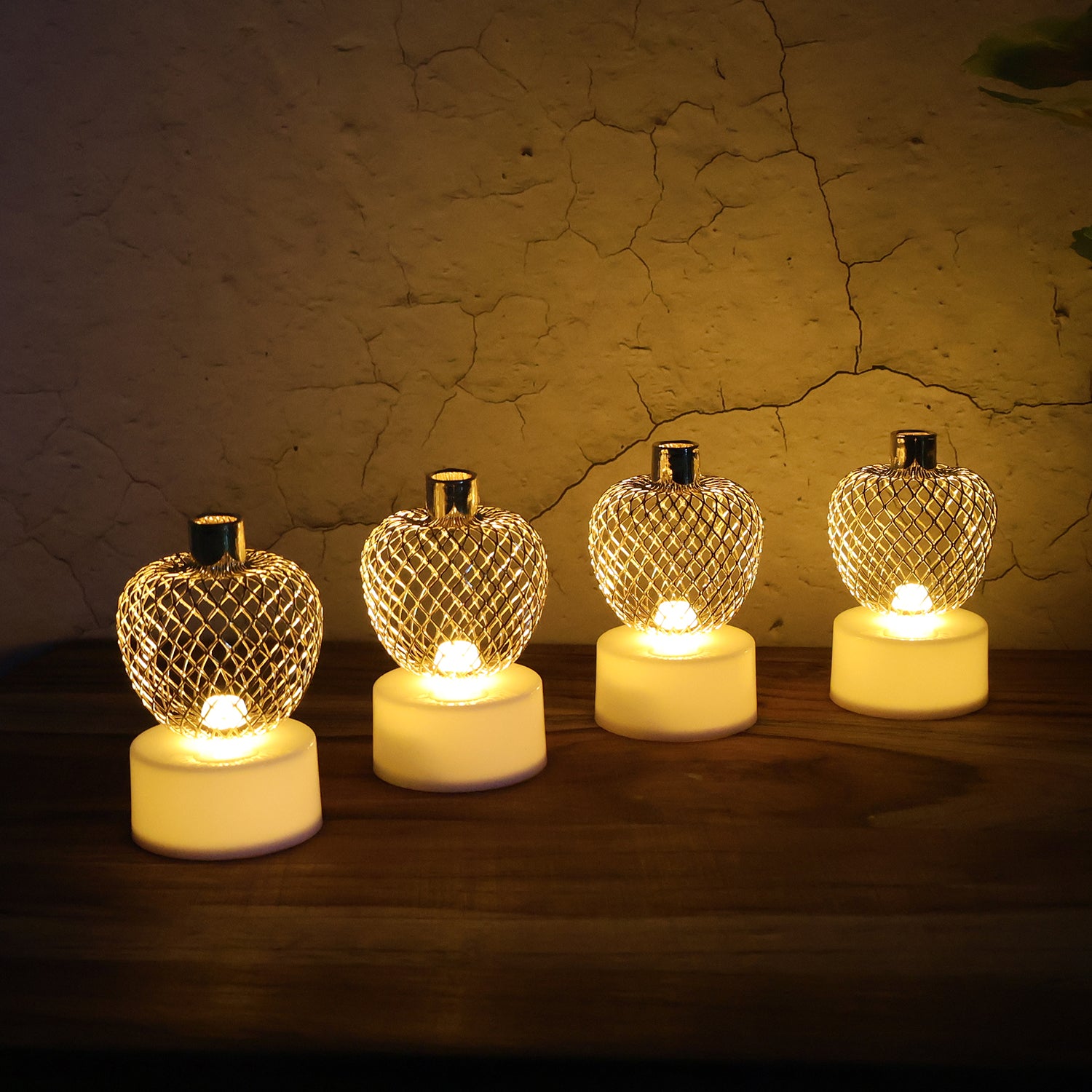 Set of four decorative apple-shaped LED tealight candles by Wukusy for home decor, featuring warm glowing lights.