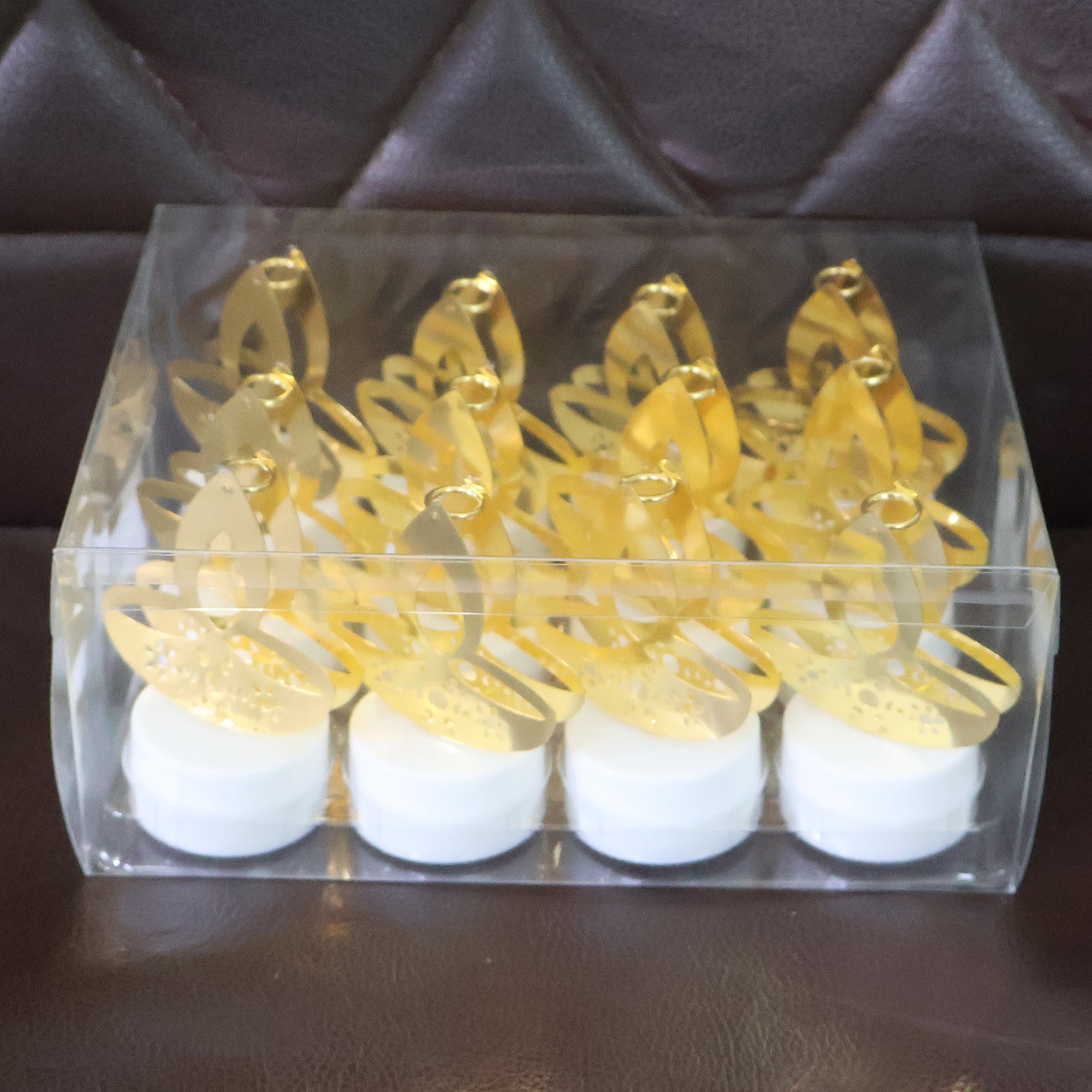 Set of 12 golden diya-shaped LED tealight candles for home decor by Wukusy, ideal for traditional and festive decorations.