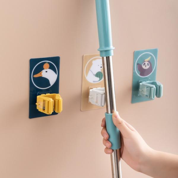 Wukusy Magic Sticker Series self-adhesive mop and broom holder for home organization, mounted on a wall with cleaning tools.