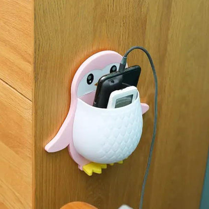 Wukusy penguin-shaped storage box holding remote, electric toothbrushes, and controllers on wall mount for home organization.