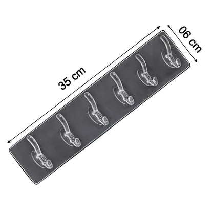 Wukusy 4654 heavy-duty transparent adhesive wall hook for home improvement, mounted on a wall with items hanging from it.