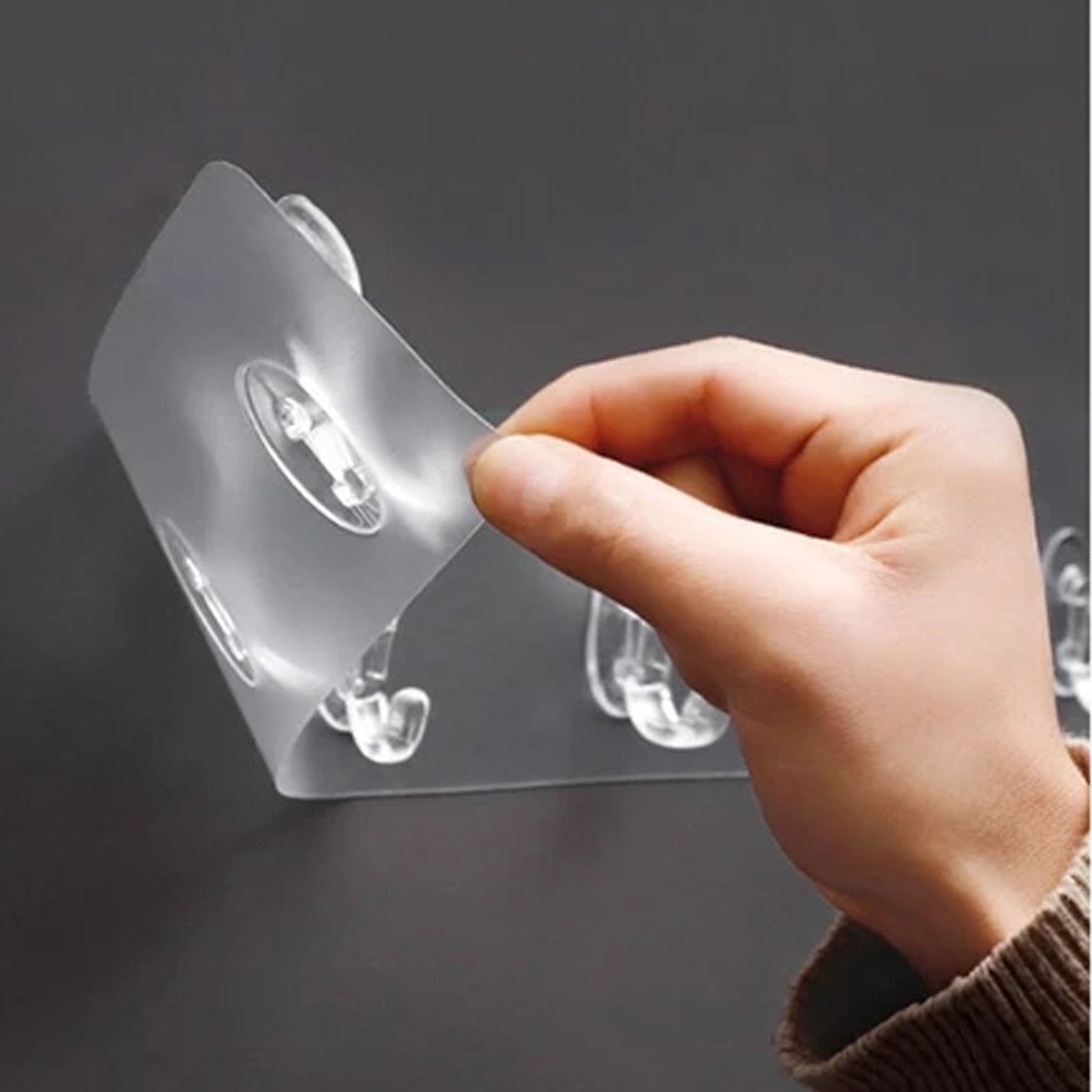 Wukusy heavy-duty transparent adhesive wall hook suitable for home improvement, mounted on a wall for hanging items.