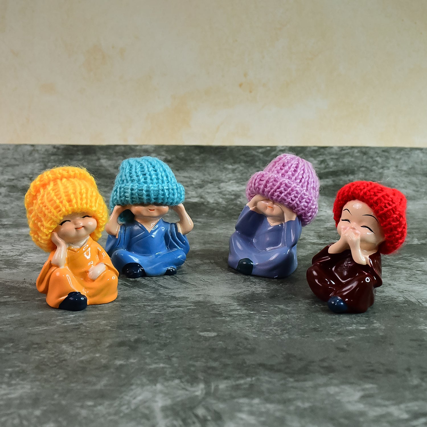 Set of four decorative resin Monk Buddha showpieces with traditional straw hats, ideal for home decor by Wukusy.