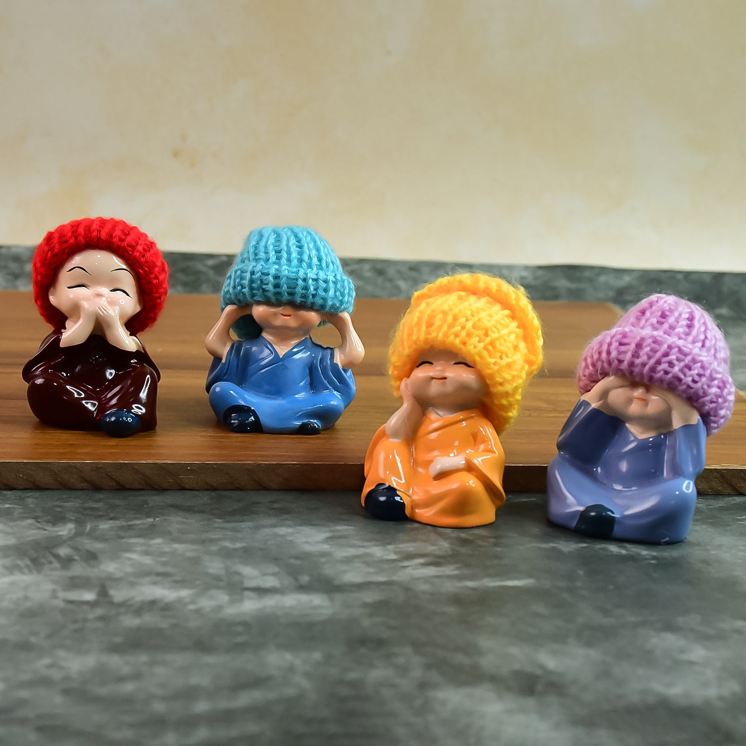 Set of four decorative resin Monk Buddha showpieces with traditional straw hats, perfect for home decor by Wukusy.