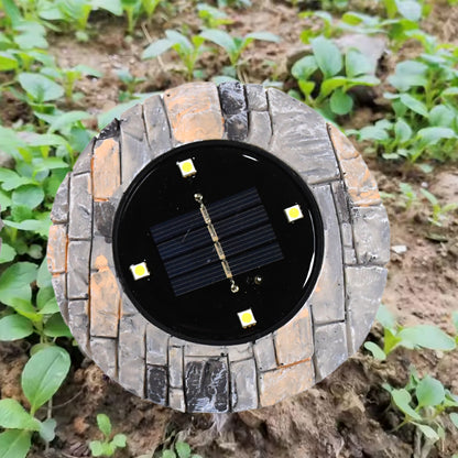 Two Wukusy heavy-duty outdoor solar disk lights with four LED bulbs each, designed for pathway illumination on slate surfaces.