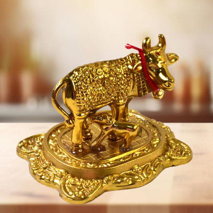 Golden metal Kamdhenu cow with calf figurine by Wukusy, decorative home improvement sculpture in gold finish.