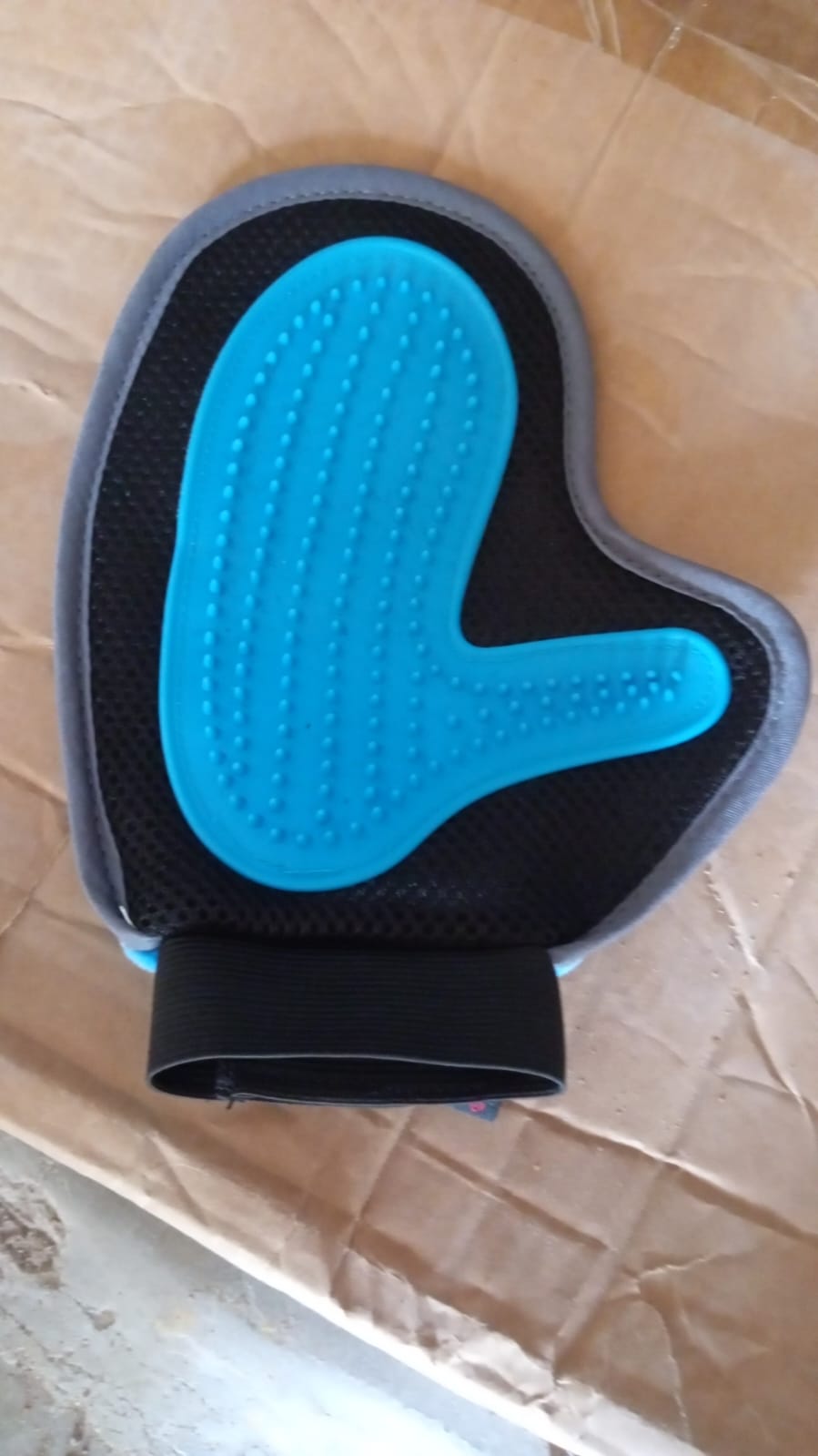Wukusy pet grooming glove with descending brush design, used for gentle pet hair removal and grooming at home.