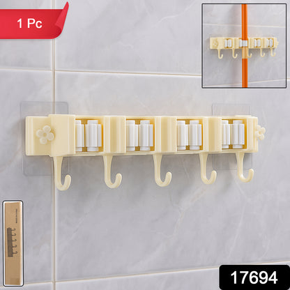 Wukusy self-adhesive wall-mount broom and mop holder rack for organized home storage, installed on a wall in a utility room.