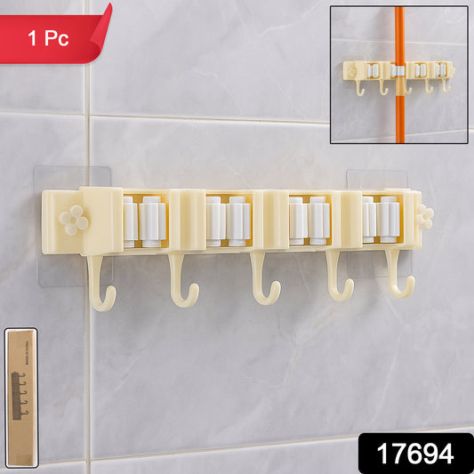Wukusy self-adhesive wall-mount broom and mop holder rack for organized home storage, installed on a wall in a utility room.