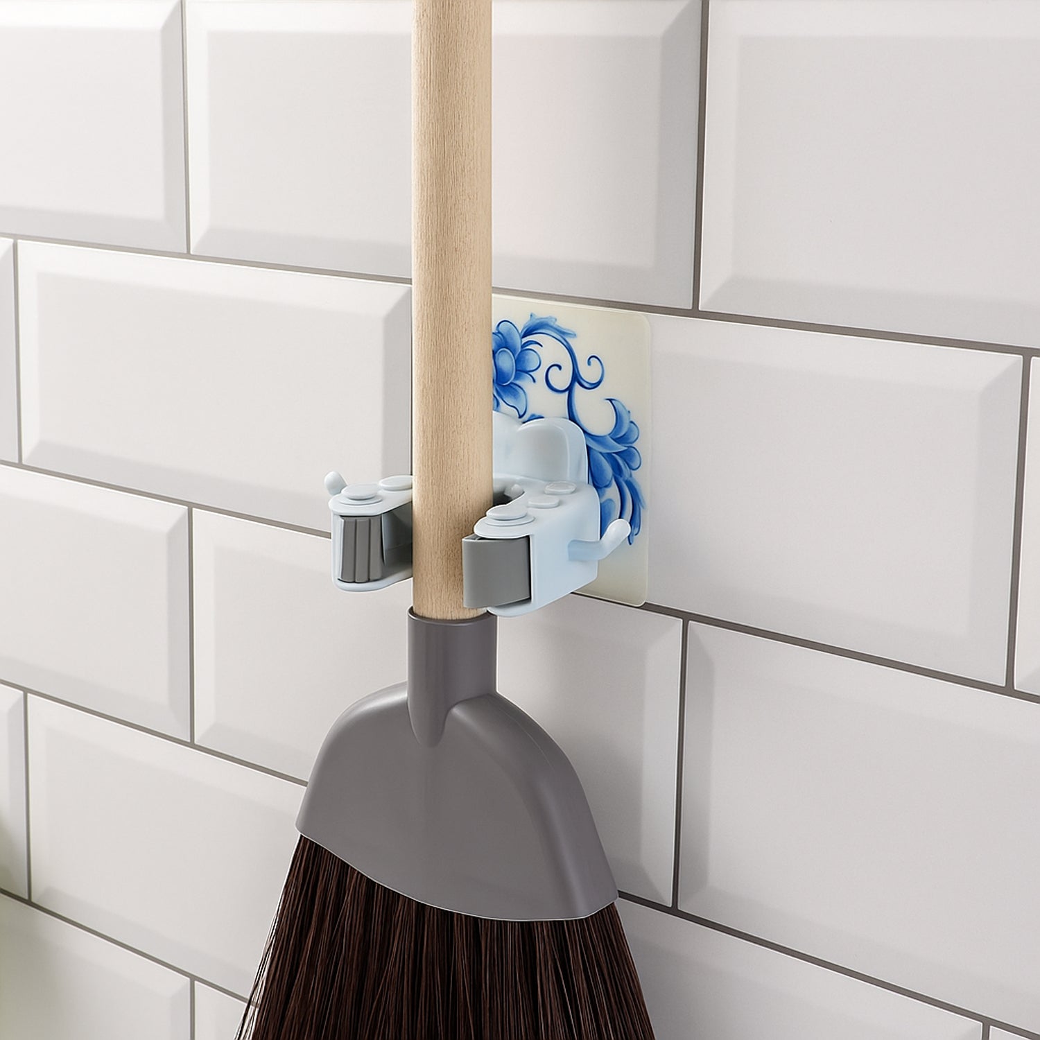 Wukusy wall-mounted mop and broom holder clip attached to a wall, organizing cleaning tools efficiently in a home improvement setting.