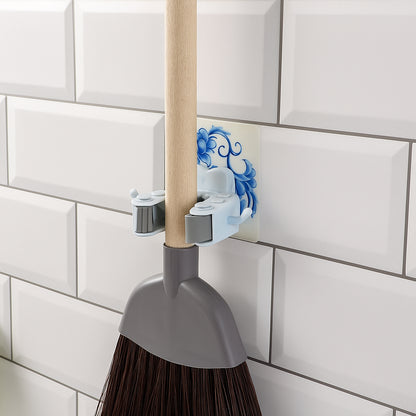 Wukusy wall-mounted mop and broom holder clip attached to a wall, organizing cleaning tools efficiently in a home improvement setting.