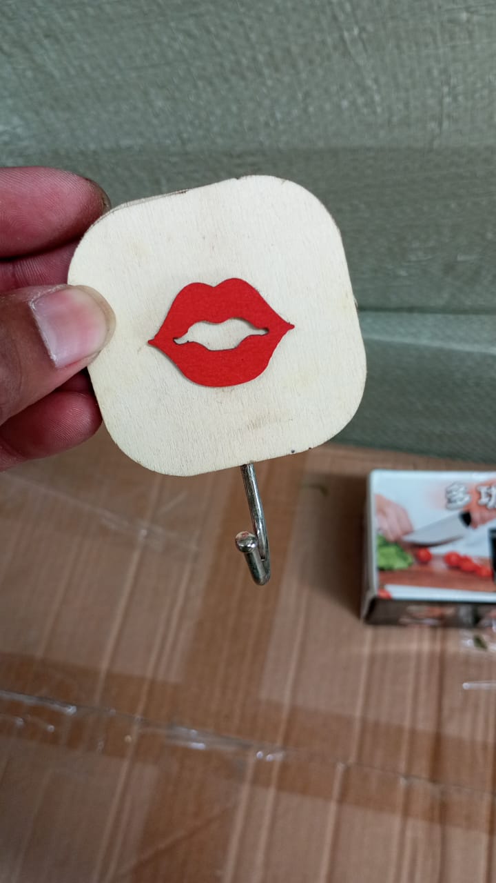 Wukusy wooden cartoon wall hook with multiple hooks for hats, coats, backpacks, towels, and clothes in a home or kitchen setting.