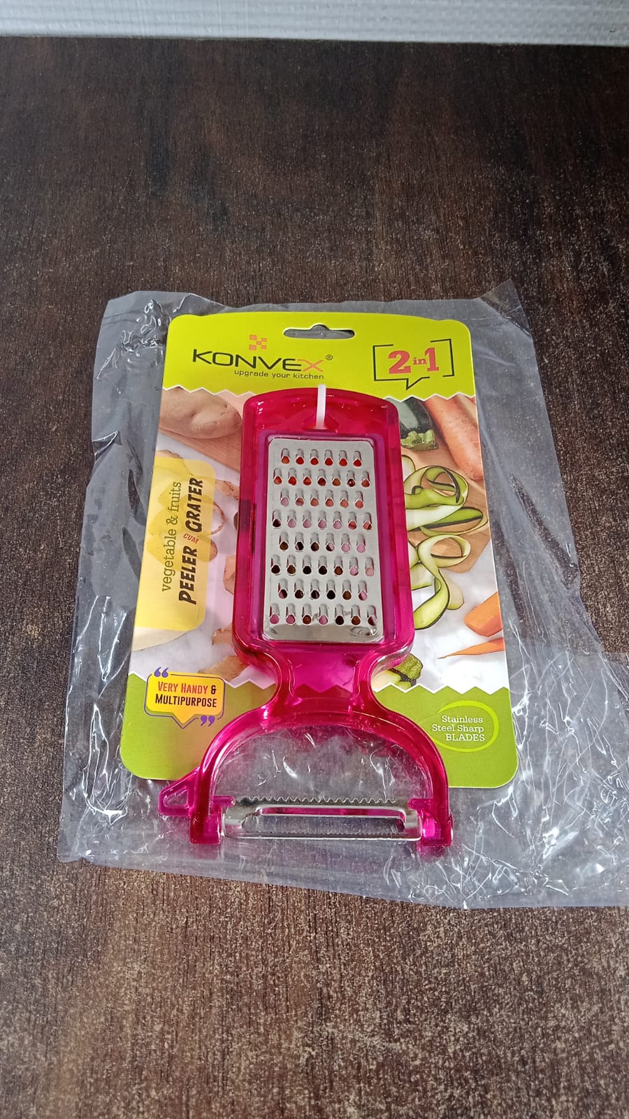 Wukusy 2-in-1 multifunctional kitchen peeler with grater, stainless steel blades, and ergonomic handle for peeling and grating vegetables.