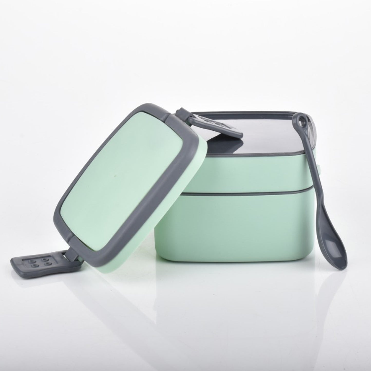 Green double-layer portable lunch box by Wukusy with a carrying handle and spoon, designed for easy stacking and meal on the go.
