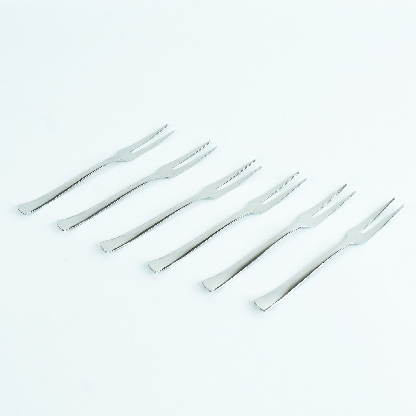 Wukusy Apex 6-in-1 stainless steel fruit fork set with multiple tines for serving and eating fruit in a modern kitchen setting.