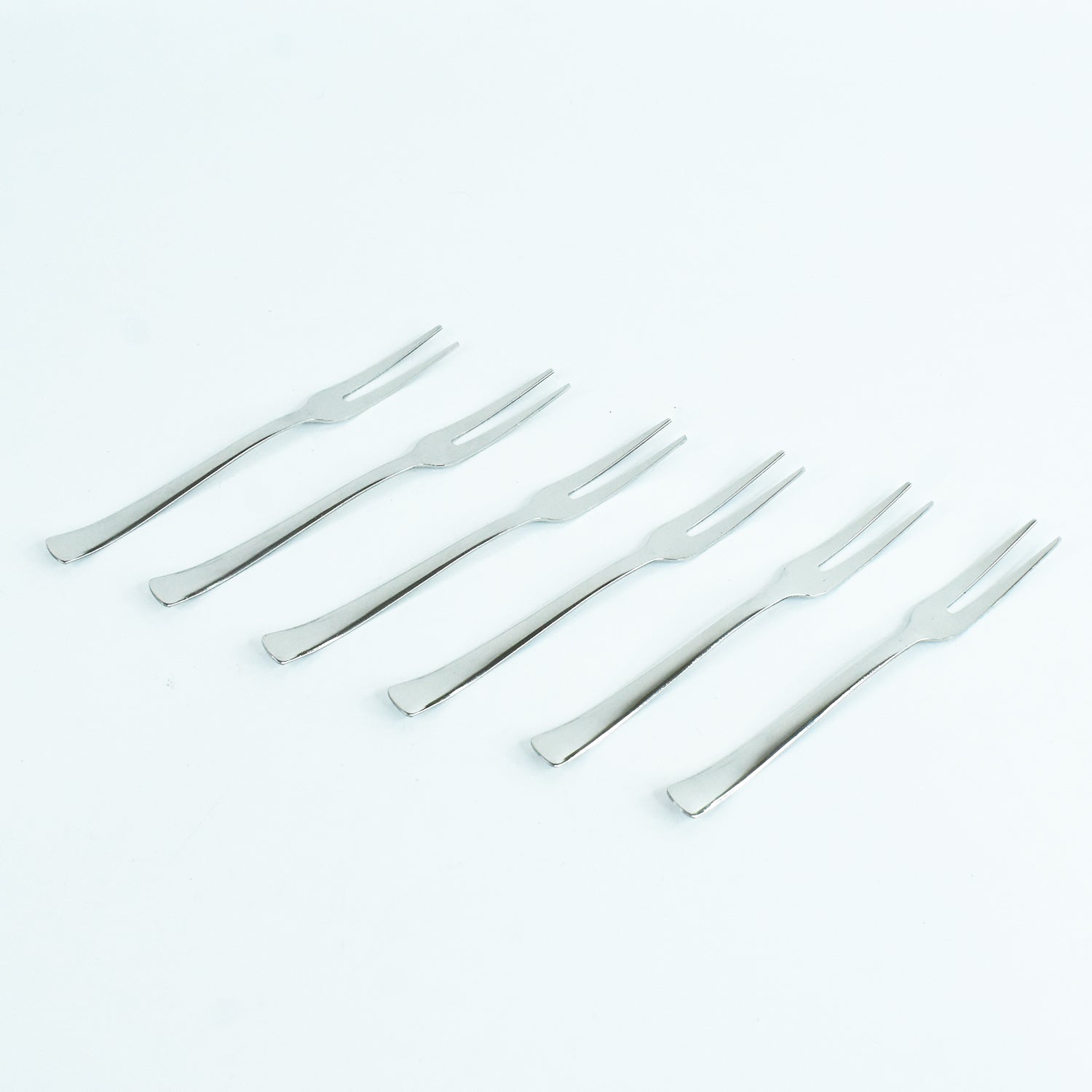 Wukusy Apex 6-in-1 stainless steel fruit fork set with multiple tines for serving and eating fruit in a modern kitchen setting.
