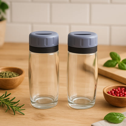 Wukusy Apex acrylic salt and pepper shaker set of 2, clear modern kitchen shakers with black tops on a white background.