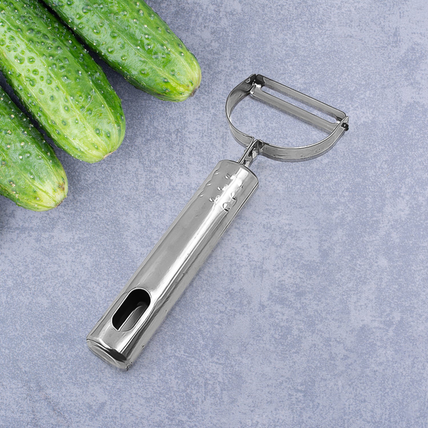Wukusy fruit and vegetable peeler tool for easy peel removal, shown on a kitchen countertop with peeled fruit and vegetables.