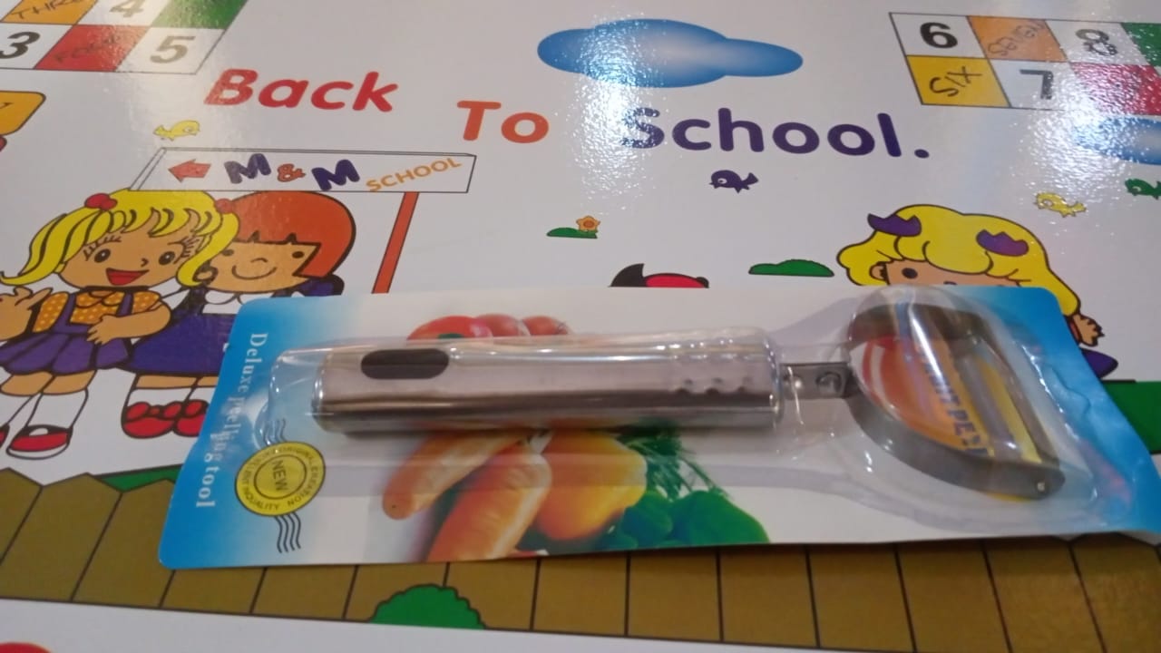 Wukusy fruit and vegetable peeler tool for easy peel removal, shown with peeled fruit and vegetables on a kitchen countertop.