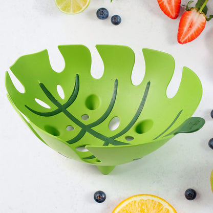 Leaf-shaped plastic fruit basket by Wukusy, designed for kitchen storage, with a textured leaf pattern and open design.