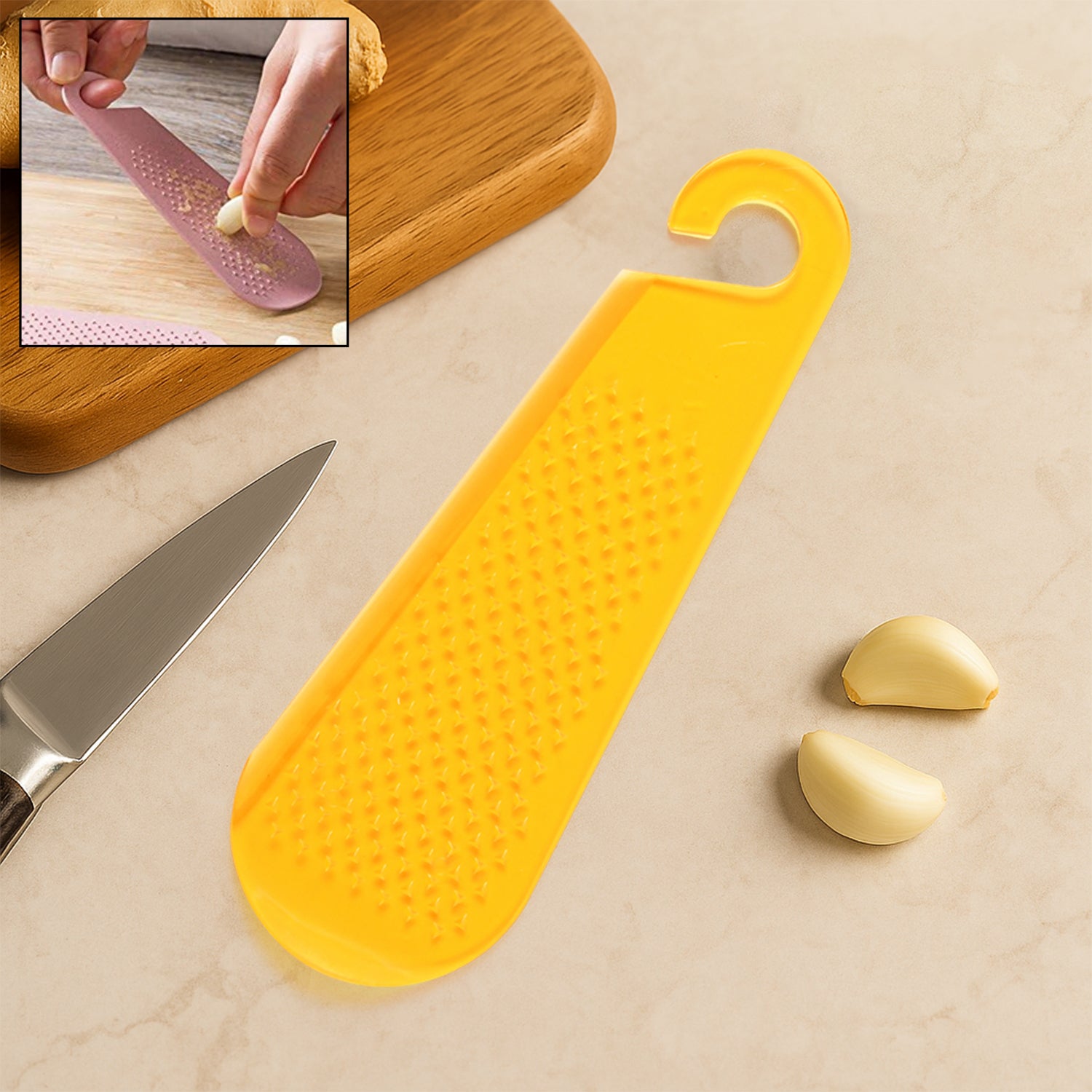 Wukusy multipurpose garlic and ginger grater and peeler tool with hanging hook for kitchen use on a countertop.