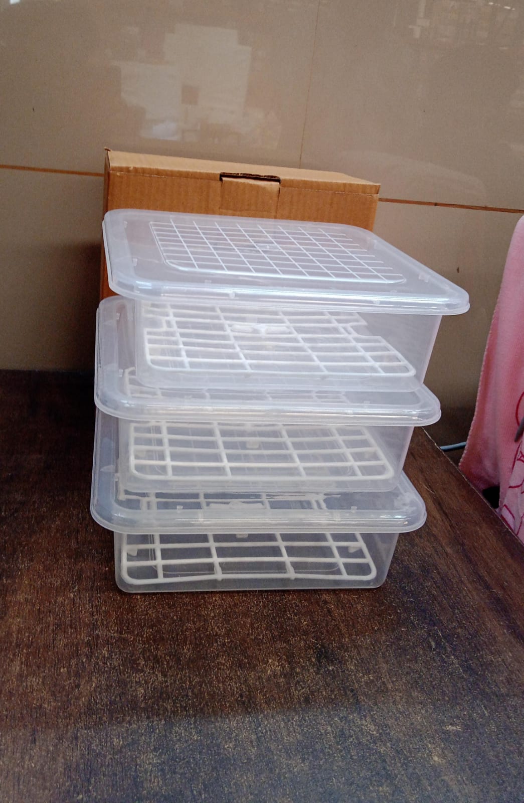 Set of three Wukusy plastic food storage containers with removable drain trays and lids, ideal for kitchen organization.