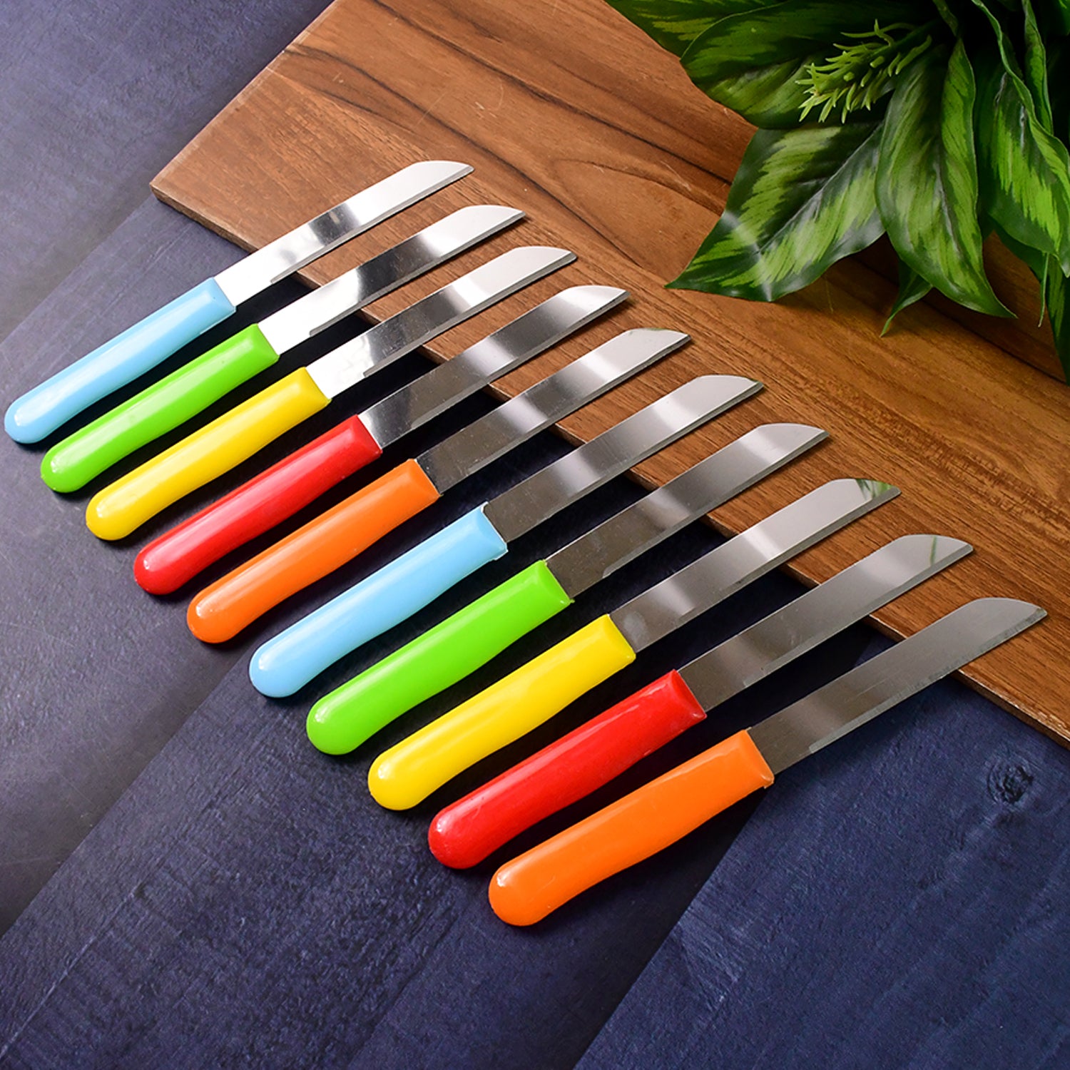 Set of 10 Wukusy stainless steel handle plain knives for kitchen use, arranged neatly on a cutting board.