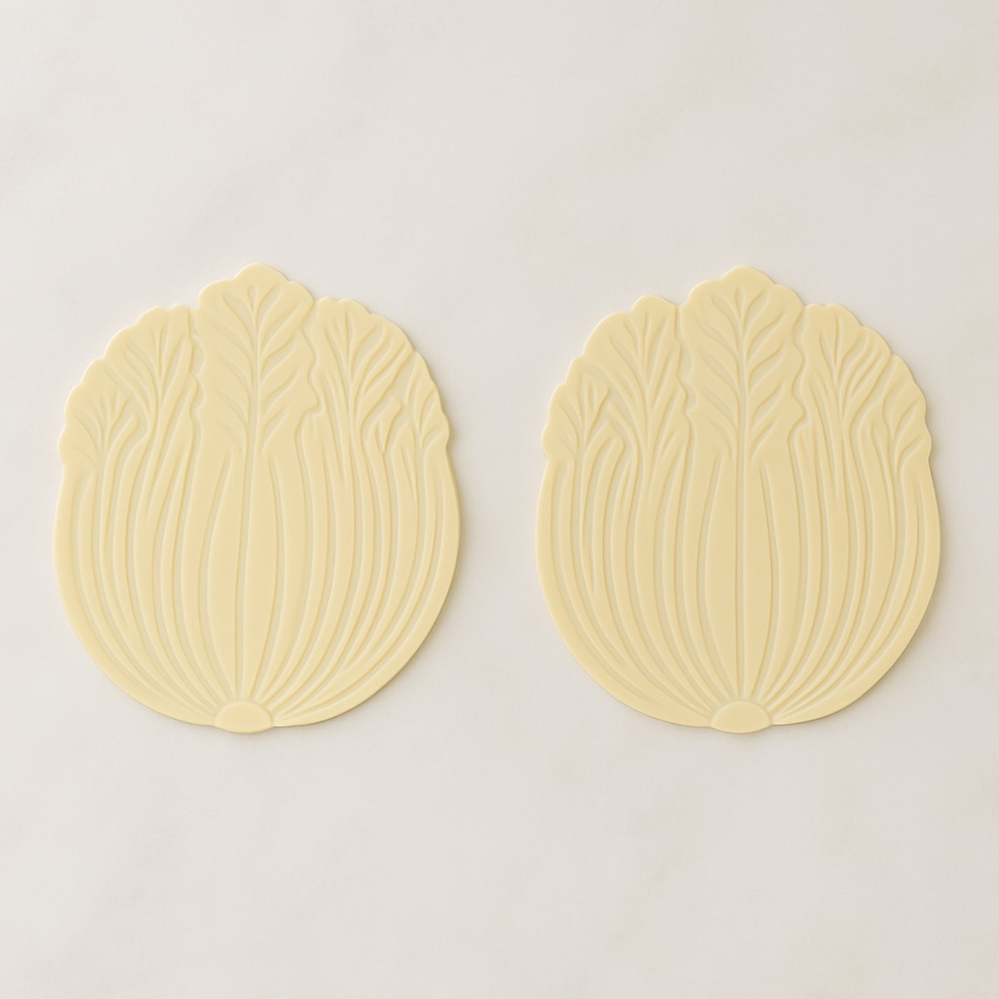 Set of two Wukusy silicone coasters with leaf design, ideal for protecting surfaces in home and kitchen spaces.
