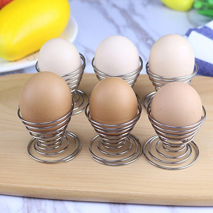 Stainless steel spring egg cup holder by Wukusy, designed to securely hold a soft-boiled egg in a modern kitchen setting.