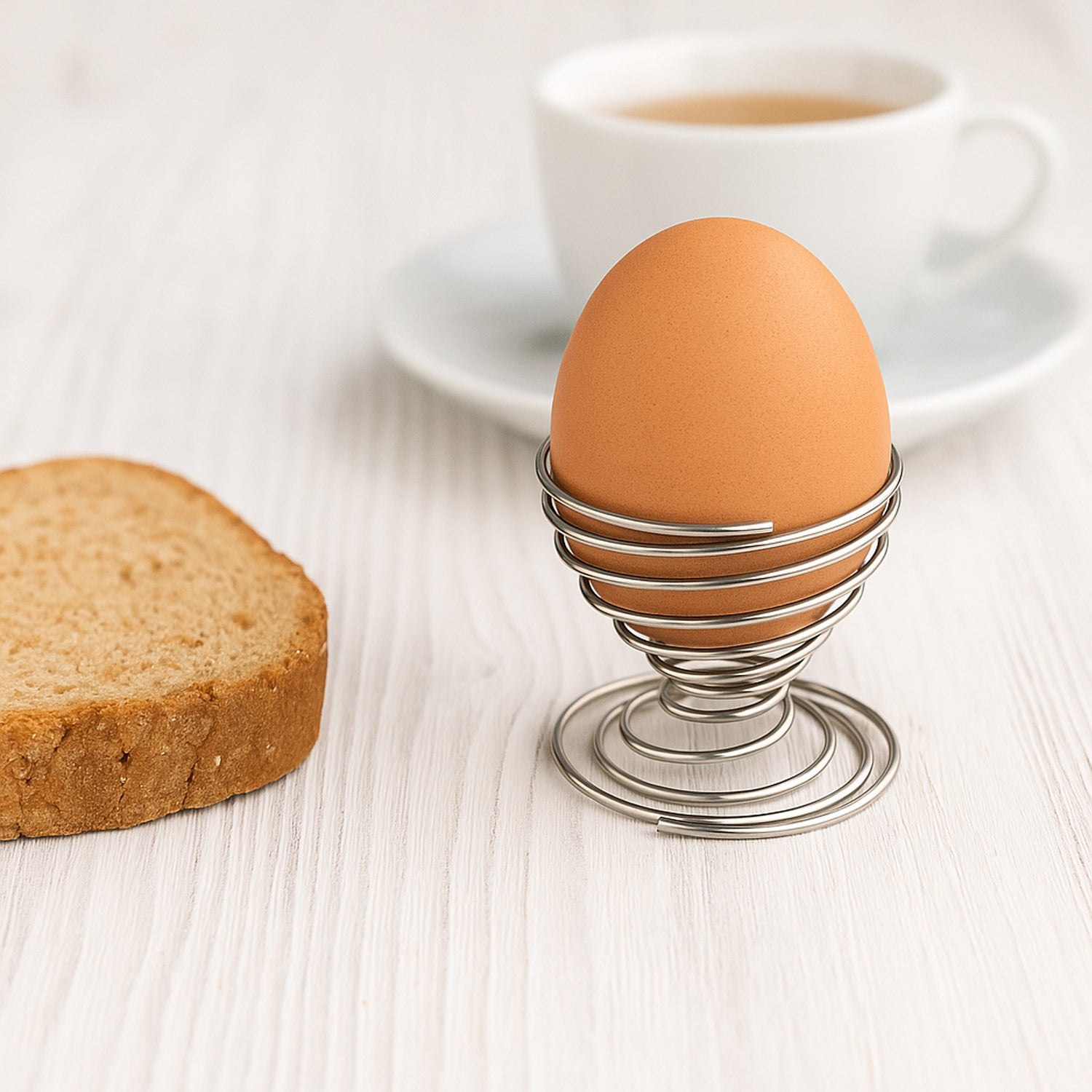 Stainless steel spring egg cup holder by Wukusy for home and kitchen use, holding a single egg securely.