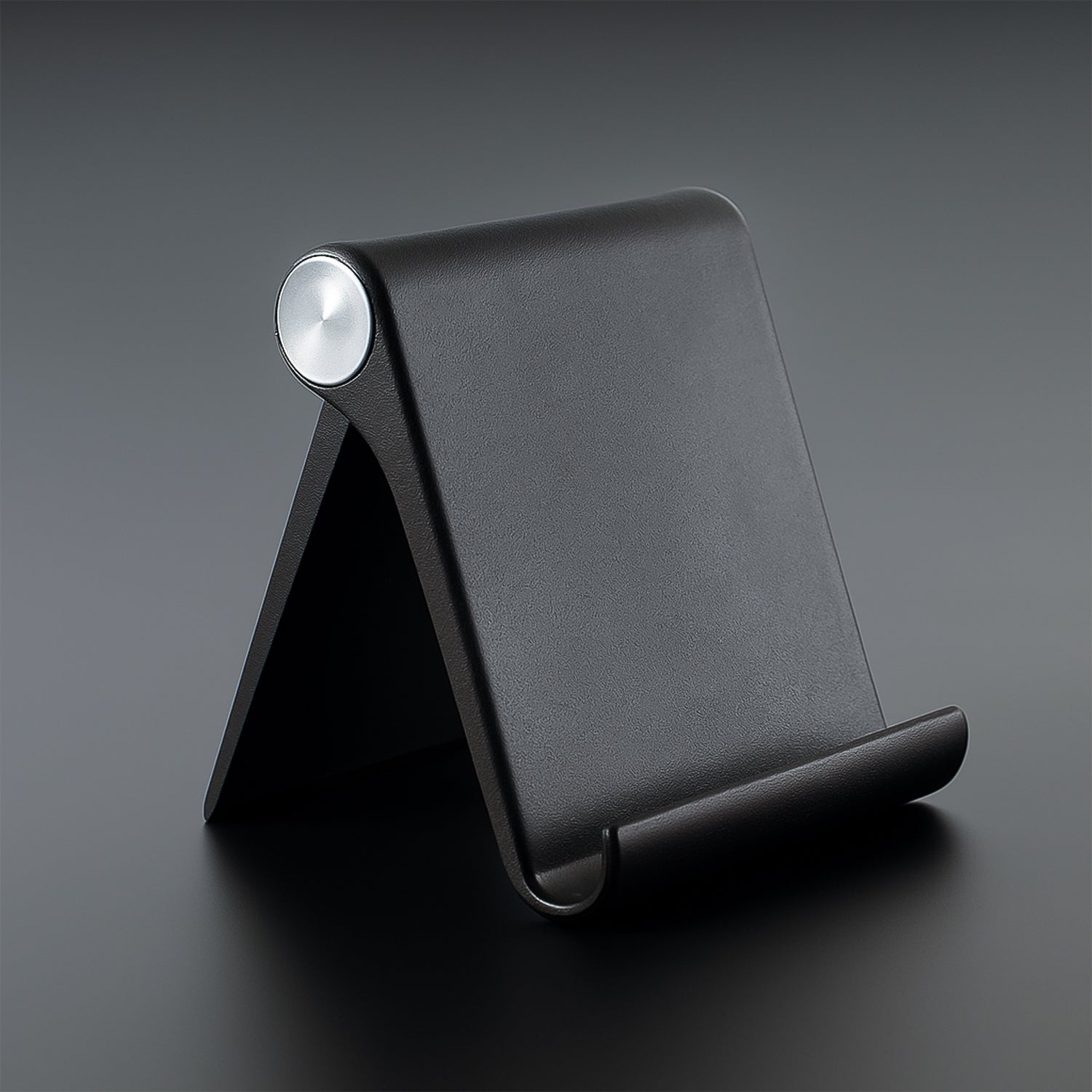 Black Wukusy plastic foldable desktop mobile stand, adjustable and lightweight for easy phone support on a desk.