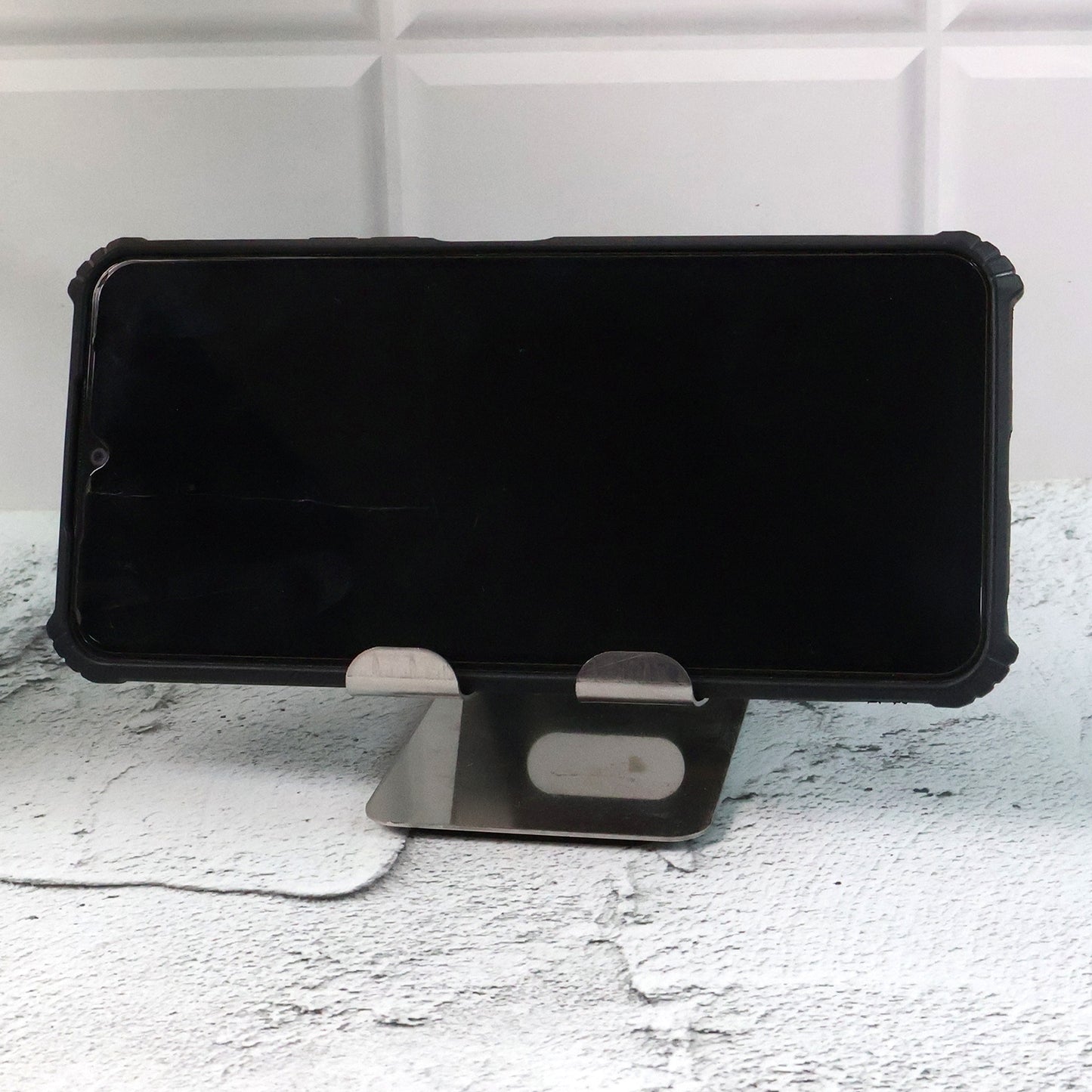 Stainless steel Wukusy universal mobile and tablet stand holder on a flat surface, designed for hands-free device support.