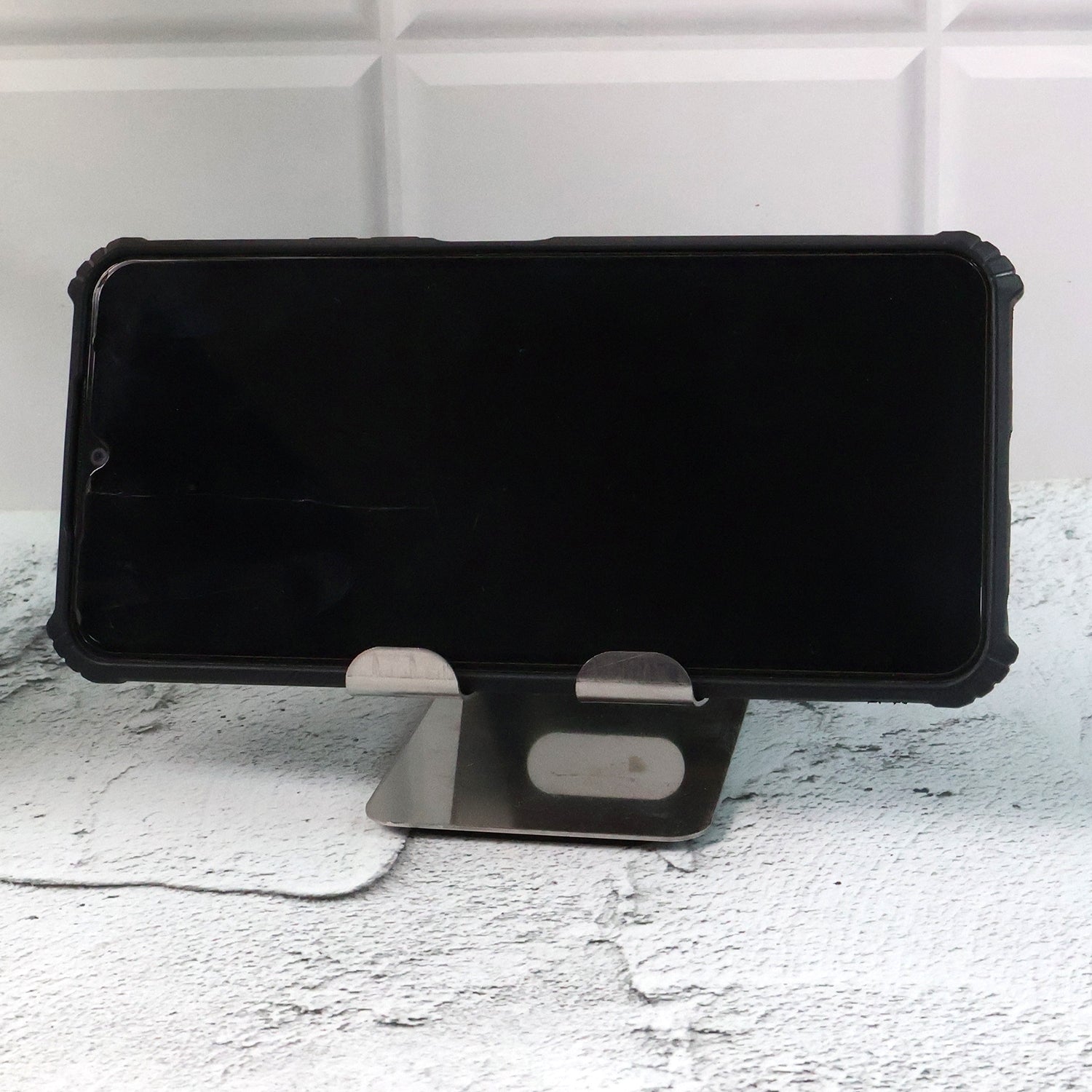 Stainless steel Wukusy universal mobile and tablet stand holder on a flat surface, designed for hands-free device support.