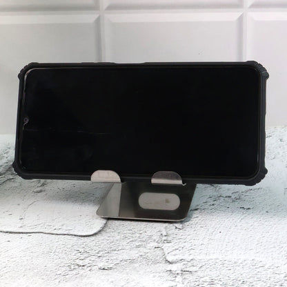Stainless steel Wukusy universal mobile and tablet stand holder on a flat surface, designed for hands-free device support.