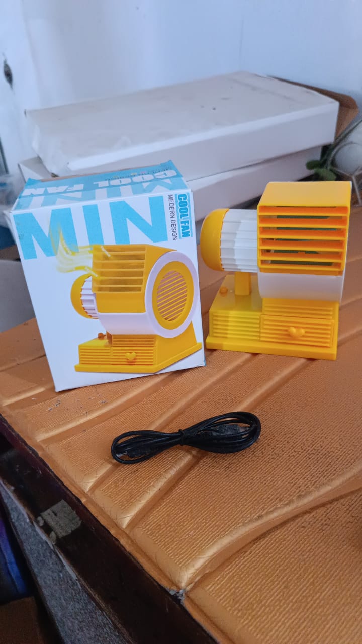 Wukusy mini dual-blade portable USB table fan on office desk, compact and lightweight for personal cooling.