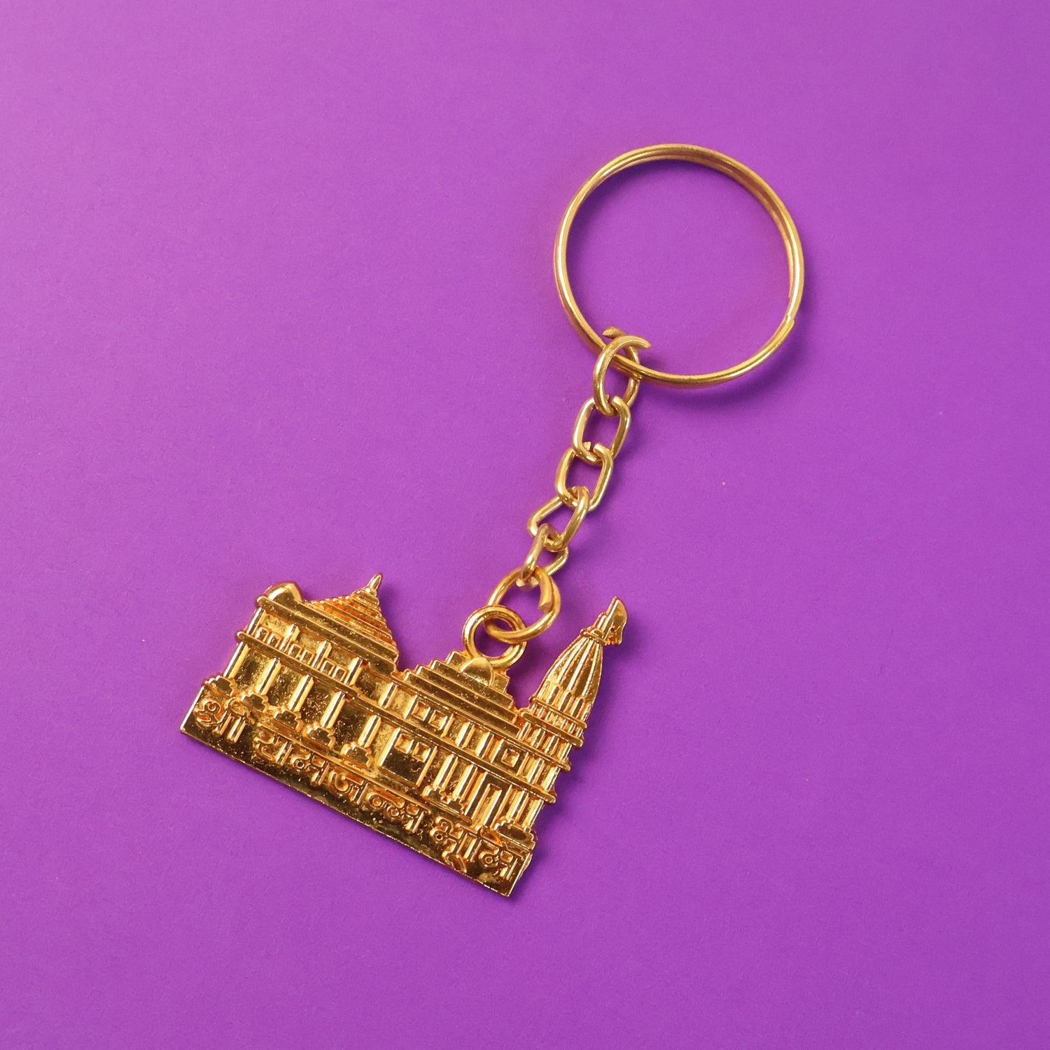 Golden metal Ram Mandir keychain from Wukusy, featuring intricate religious temple design on a durable keychain.