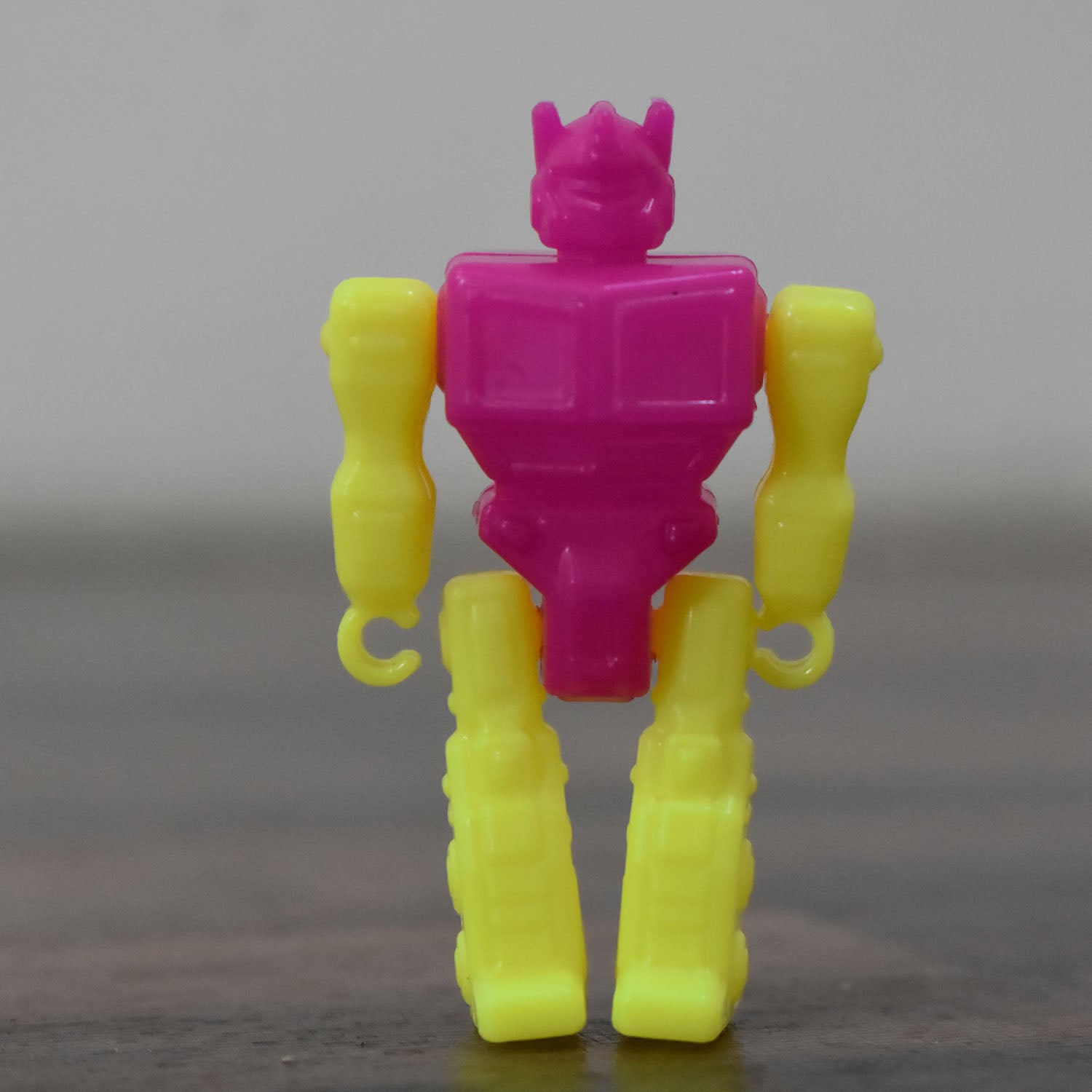 Small Wukusy robot toy, colorful plastic robot figure with movable arms and legs, perfect for kids' play and collection.
