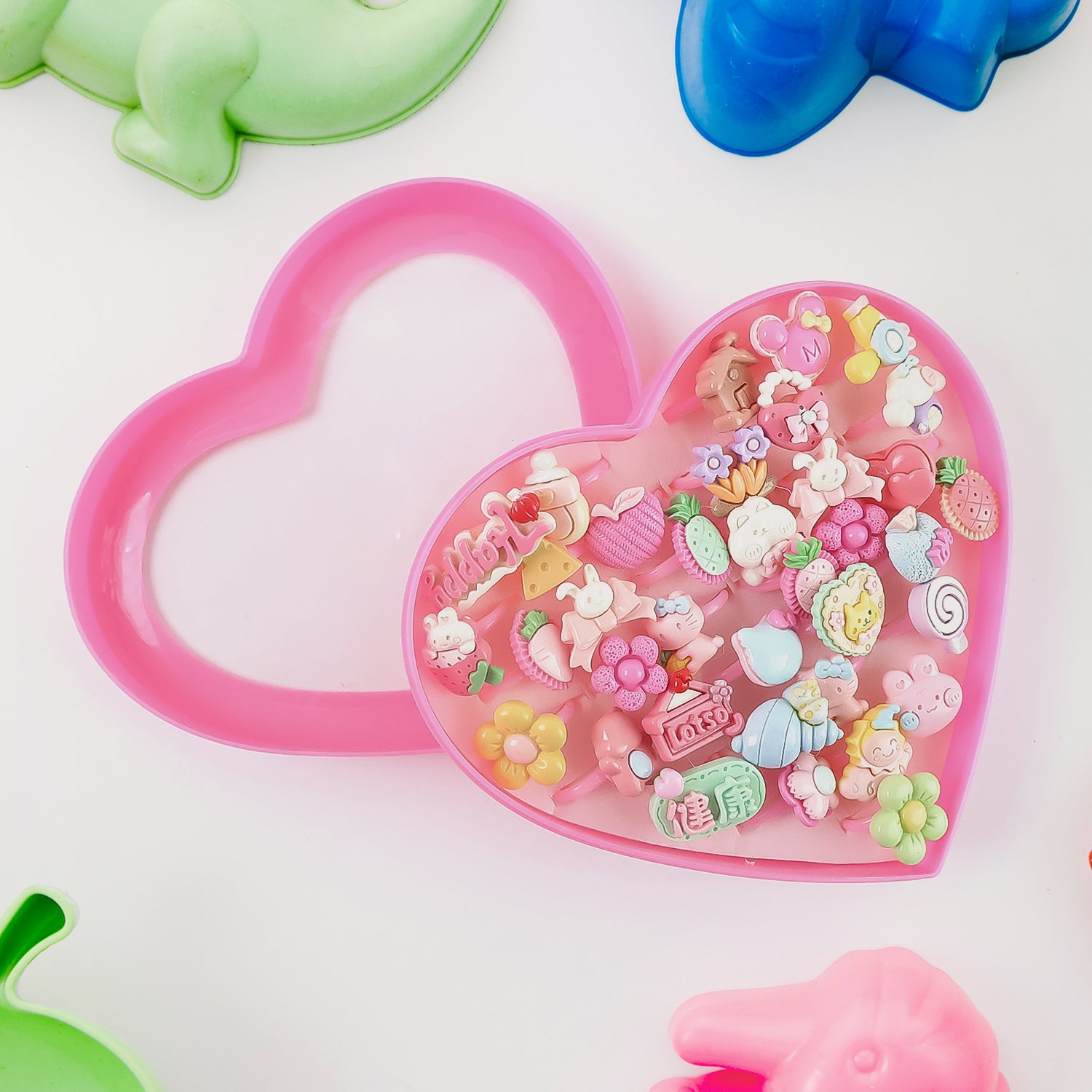 Set of 35 playful decorative toy rings for children in a heart-shaped storage box by Wukusy, featuring colorful and fun designs.