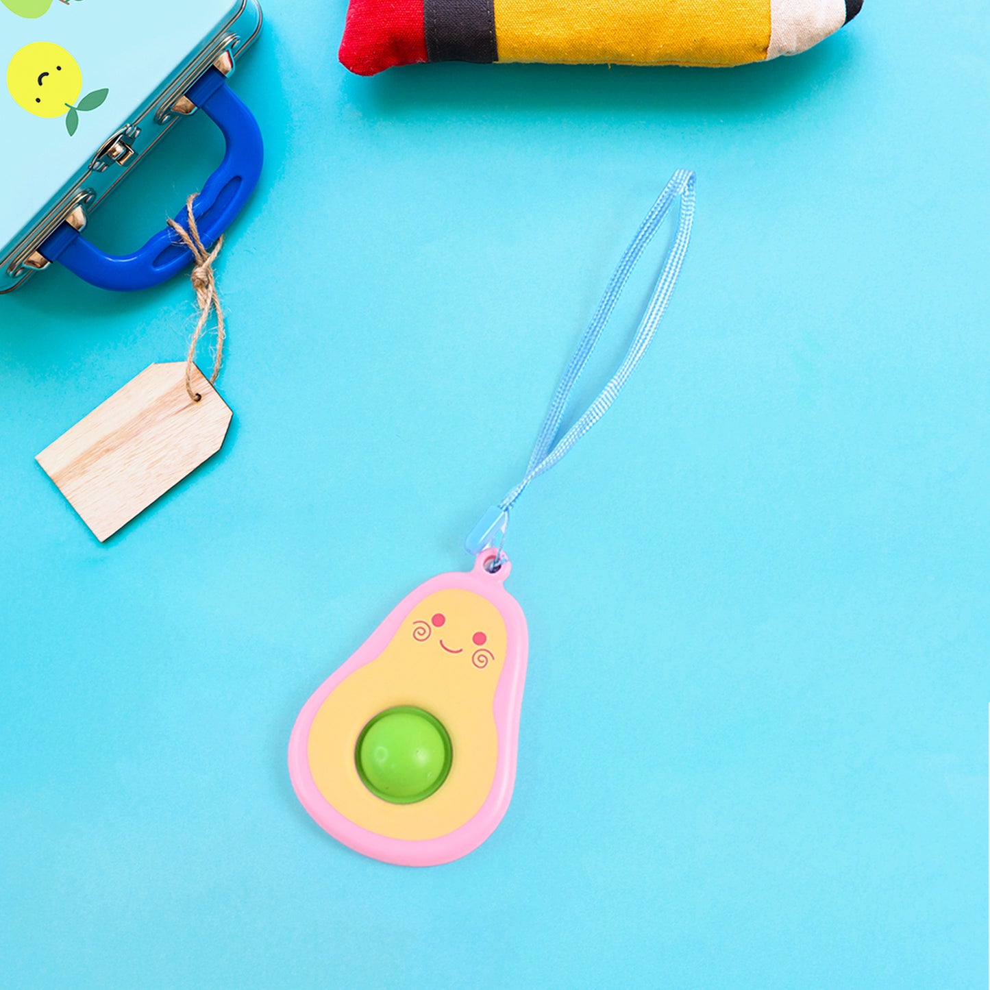 Cute avocado-shaped mini push pop keychain toy from Wukusy with a strap, featuring vibrant green avocado design and small size.