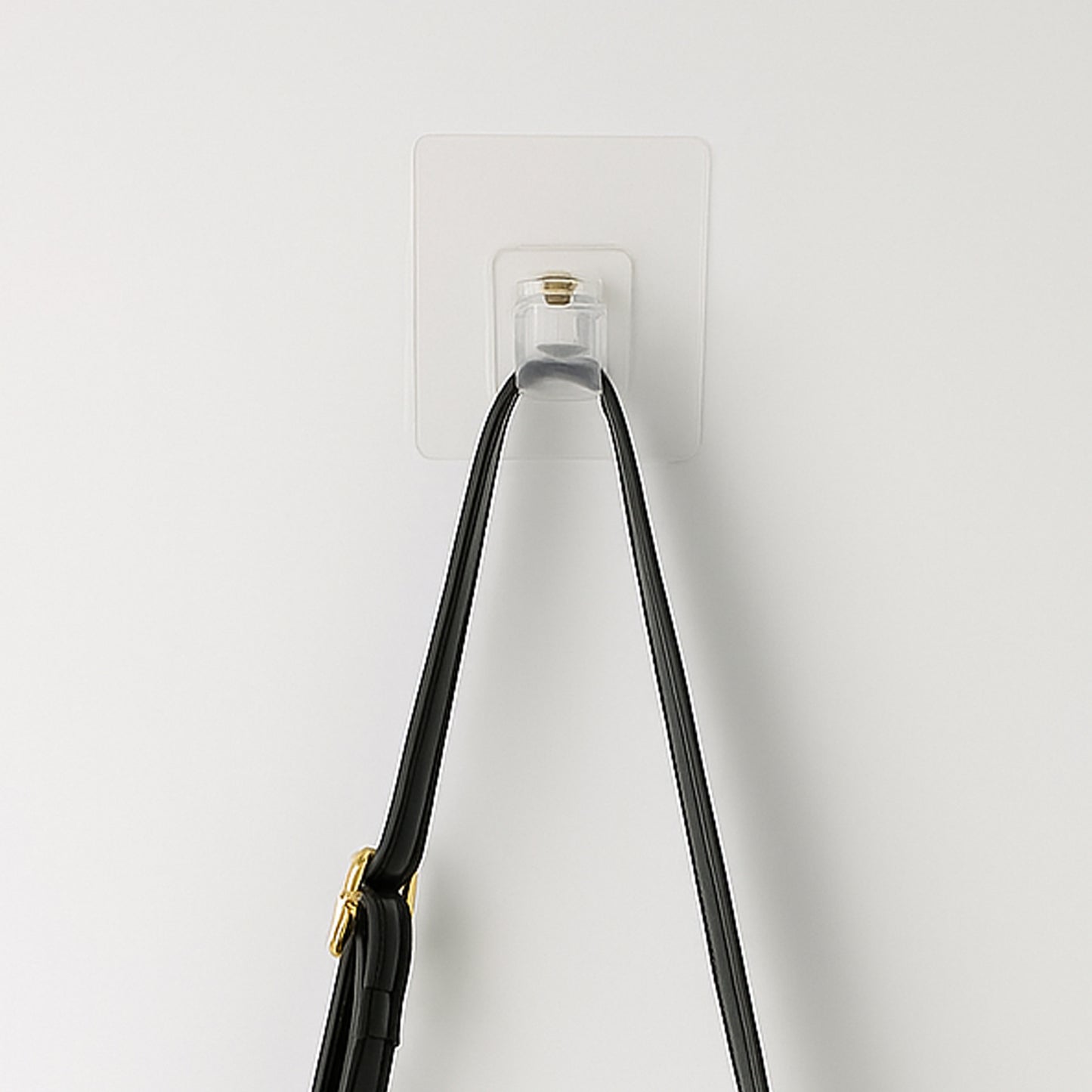 Transparent self-adhesive wall hook holder clip by Wukusy attached to a wall for hanging lightweight items.