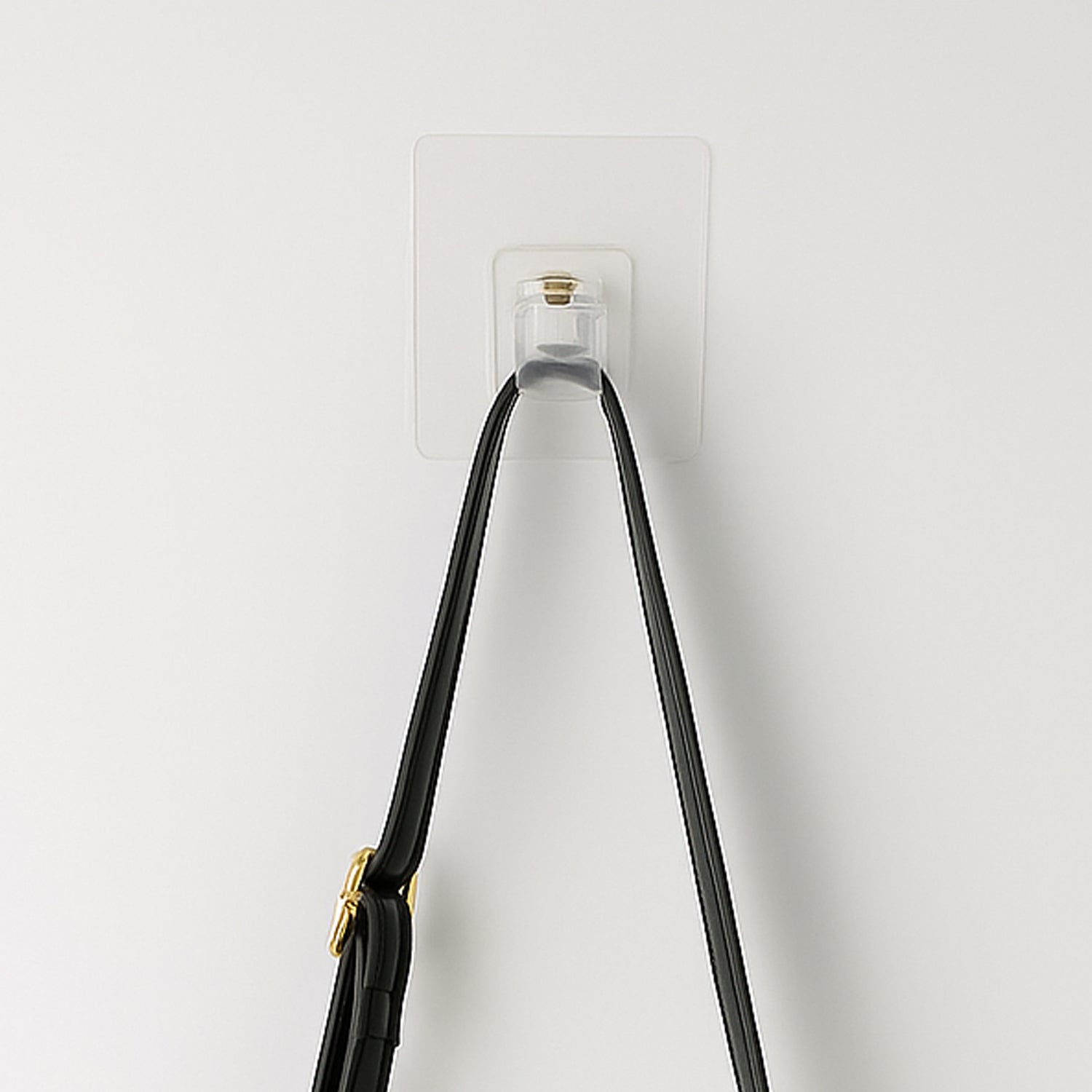 Transparent self-adhesive wall hook holder clip by Wukusy attached to a wall for hanging lightweight items.