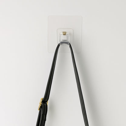 Transparent self-adhesive wall hook holder clip by Wukusy attached to a wall for hanging lightweight items.