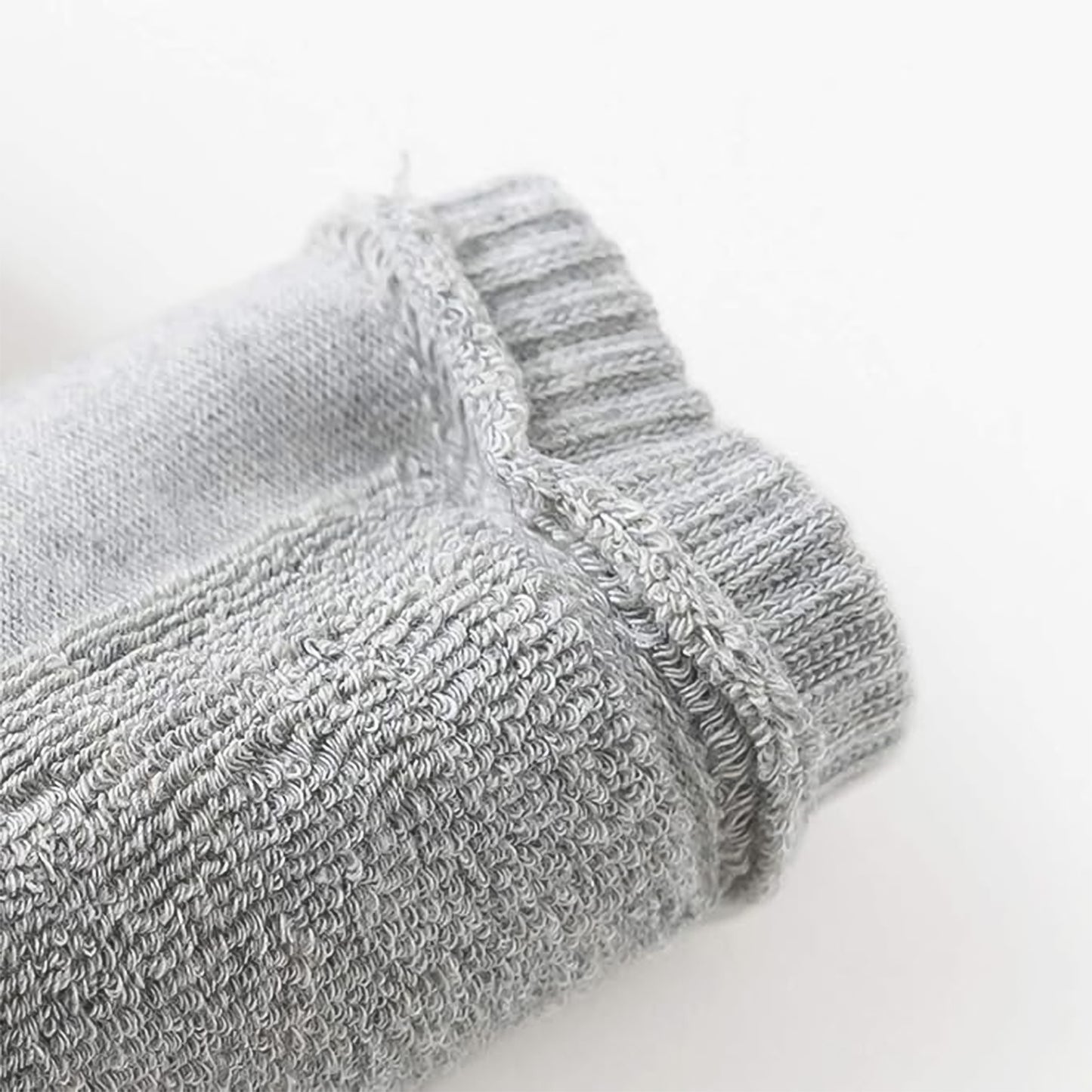 Light grey toddler wool knit leg warmer by Wukusy, cozy knee guard for baby care, shown on a young child's leg.