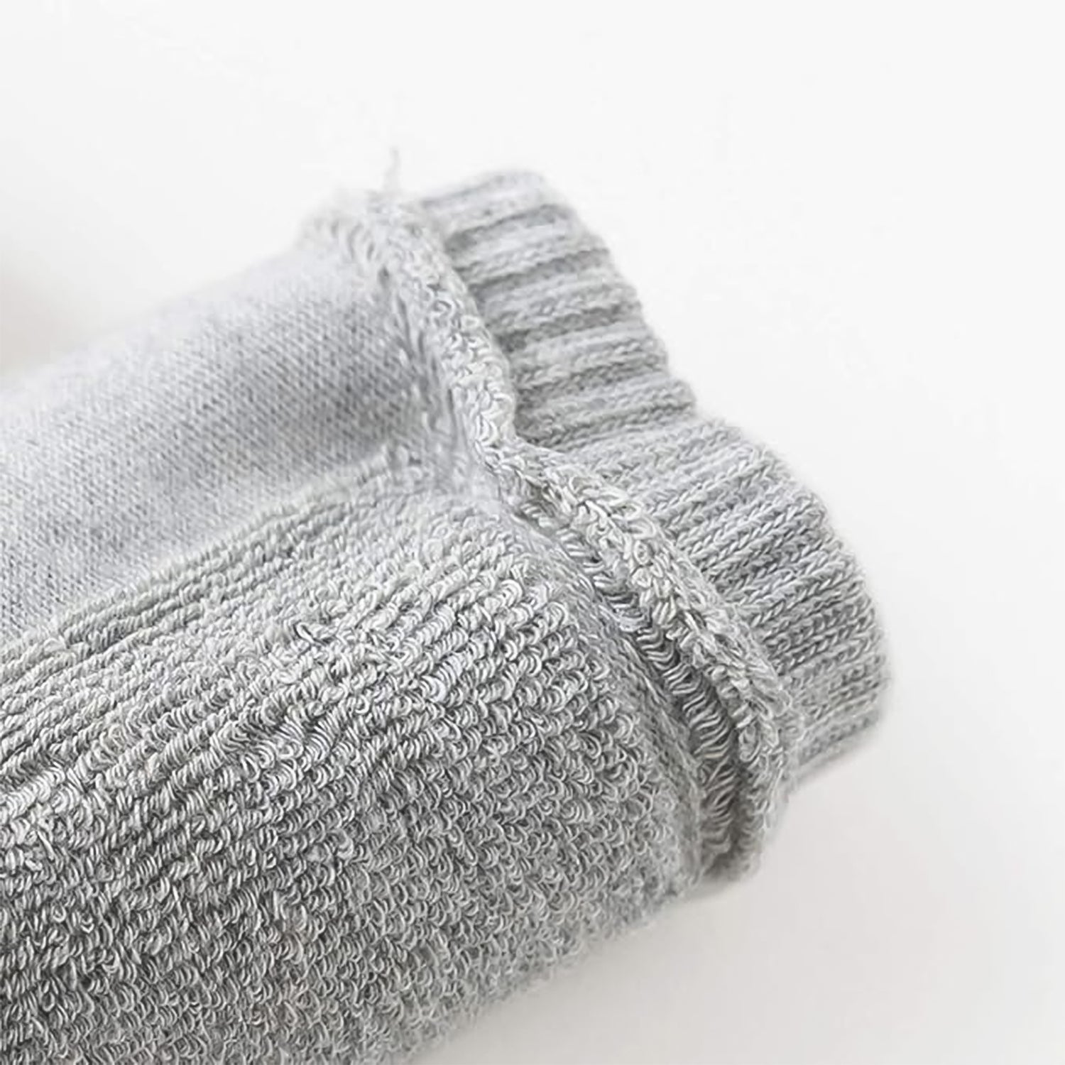 Light grey toddler wool knit leg warmer by Wukusy, cozy knee guard for baby care, shown on a young child's leg.