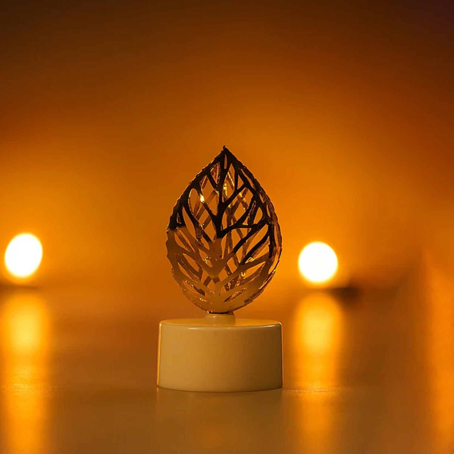 Set of four Wukusy decorative golden leaf-shaped flameless LED candles for home decor, with warm glowing light.