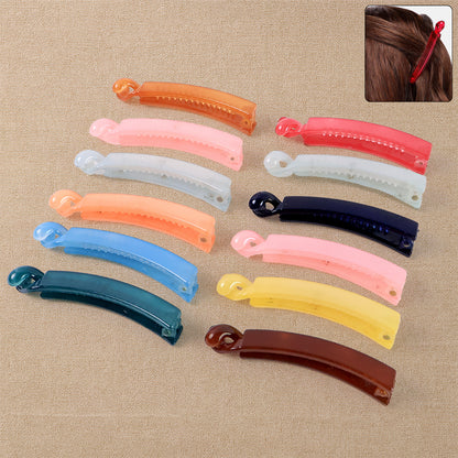 Set of 12 multicolor plastic banana-shaped hair clips by Wukusy, showing vibrant yellow, pink, blue, and green clips on a white background.