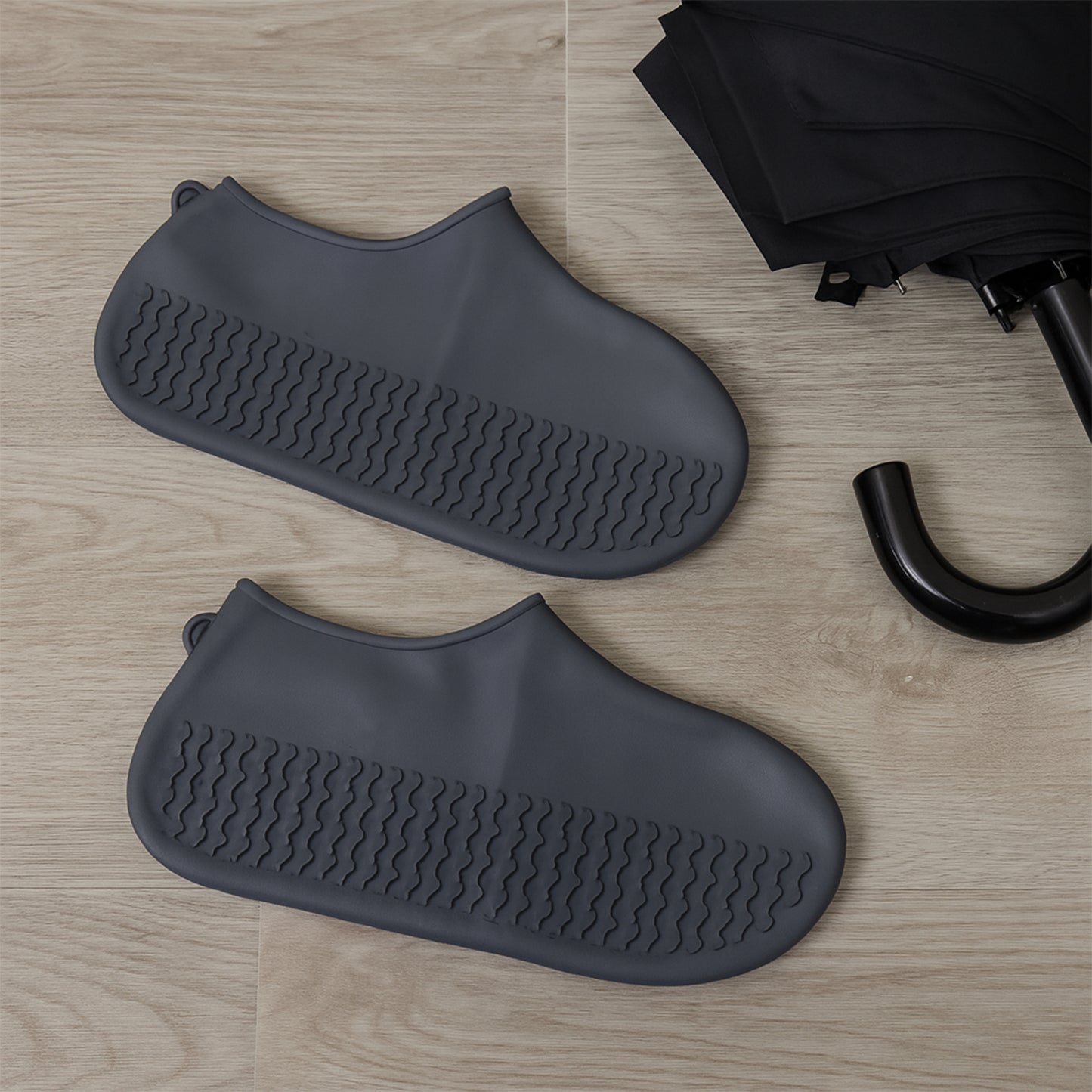 Pair of grey Wukusy non-slip silicone rain boot covers showing waterproof, foldable design with anti-skid soles for travel.