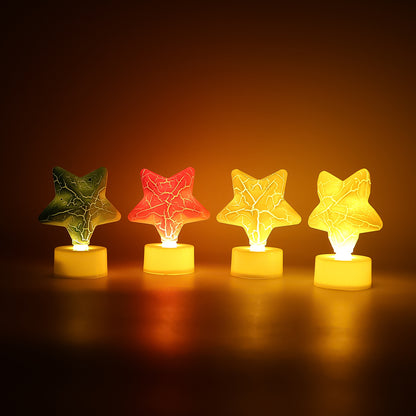Set of four star-shaped decorative LED tealight candles by Wukusy for home decor, glowing softly in a cozy setting.